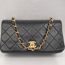 Load image into Gallery viewer, This Chanel Vintage Mini Matelasse Full Flap bag is black in the stitched diamond pattern. The chain is gold with a strip of black leather woven through it. The clasp is gold with the interlocking C&#39;s.
