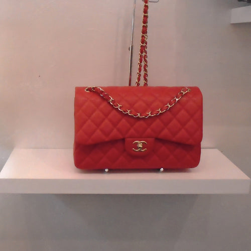 This Chanel Vintage Red Jumbo Double Flap has a diamond design caviar leather  with a tab coming down from flap with double Cs on flap. It has gold hardware and the gold shoulder chain has red leather interwoven between the chain links.