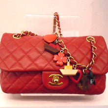 Load image into Gallery viewer, This Chanel Vintage Charm Lambskin Single Flap has a diamond pattern and a tab on middle of flap with CC logo. It has gold hardware with a red leather strip interwoven between the links and wooden charms of hearts, flowers, ships and anchors attached to the chain. 
