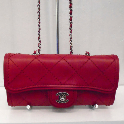 This Chanel Vintage Ultimate Stitch WOC is made of lambskin leather that is a in a sangria red color. It has silver hardware which includes the double C logo clasp and shoulder chain. A sangria red leather shoulder guard is included on the chain along with a leather strip threaded between the links of the shoulder chain. There is a pocket on the back of the bag made of the same material as the bag.