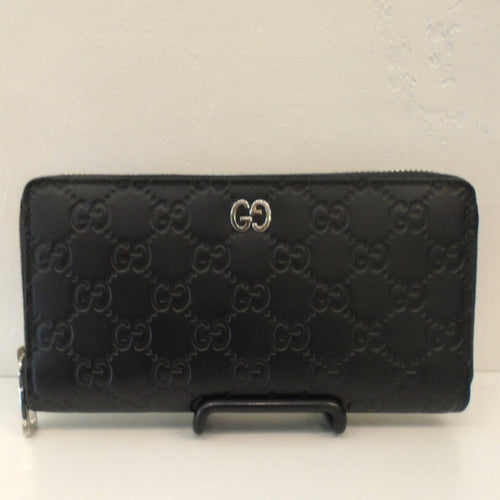 This Gucci Vintage Black GG Wallet has the Gucci diamond design and silver hardware. It has the double GG in silver on the front of the wallet and a zippered opening. The inside of the wallet has compartments for cards, bills and change.
