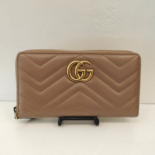 This Gucci Vintage Marmont Zippy is a warm tan color and has gold Gucci GGs on the front. It has the Gucci GGs stitched on the back and has a zippered opening. Inside there are compartments for cards, bills and change.