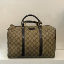 Load image into Gallery viewer, This Gucci Vintage Treated Canvas Supreme Handbag is light brown with the Gucci logo design in a darker brown and two straps coming up the front and back center of the bag in a darker brown. The double handles match the center strap color. This bag has gold hardware and zips open at the top of the bag.
