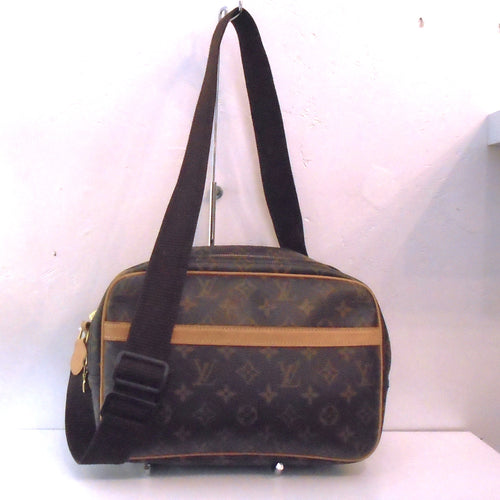 This Louis Vuitton Vintage Monogram Reporter PM has a camel leather strip on the front pocket of the bag, double zippers on the opening and a thick brown fabric adjustable shoulder strap. The inside of the bag is cream colored with an inside zippered pocket.