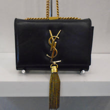 Load image into Gallery viewer, This YSL Kate Black Leather has gold hardware which includes the letters YSL on the front flap of the bag, a tassle at the bottom of the front flap and a long shoulder chain.
